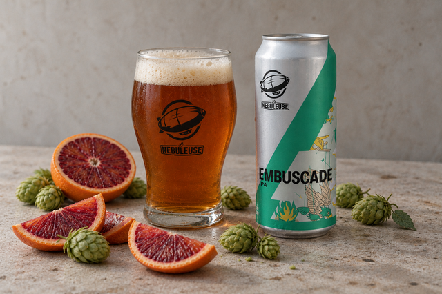Une canette à côté d'un verre et du pamplemousse et houblon au sol
