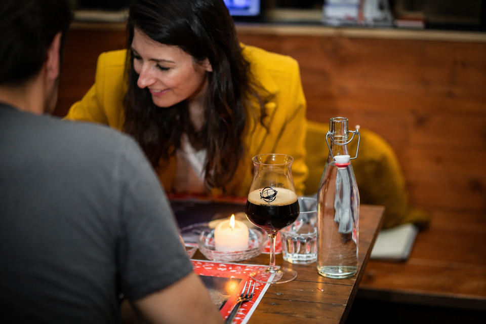 Un couple qui déjeune au restaurant avec un verre de bière.