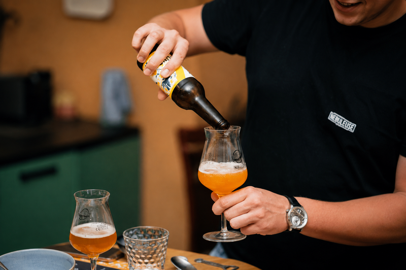 Un homme qui verse une bière dans un verre.